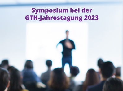 Ein Referent steht auf einer Bühne vor der Zuhörerschaft