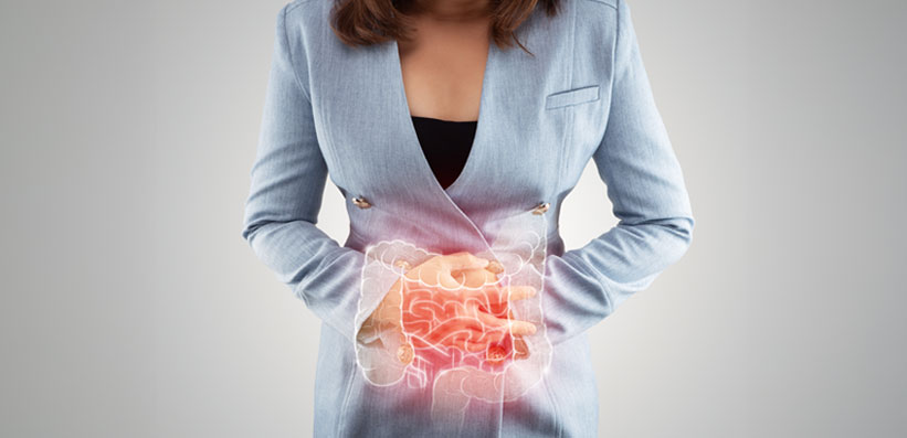 Junge Frau hält sich den Bauch wegen Verstopfungs-Schmerzen