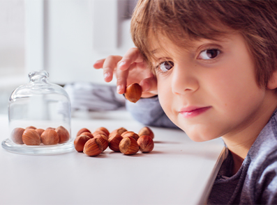 Porträt eines Jungen mit Haselnüssen