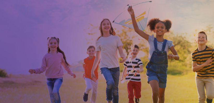 Mehrere Kinder spielen mit einem Lenkdrachen