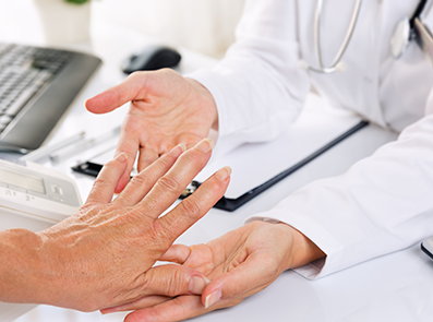 Arzt hält rheumatische Hände eines Patienten